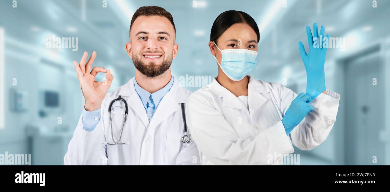 A male doctor giving an okay sign and a female doctor wearing a surgical mask Stock Photo