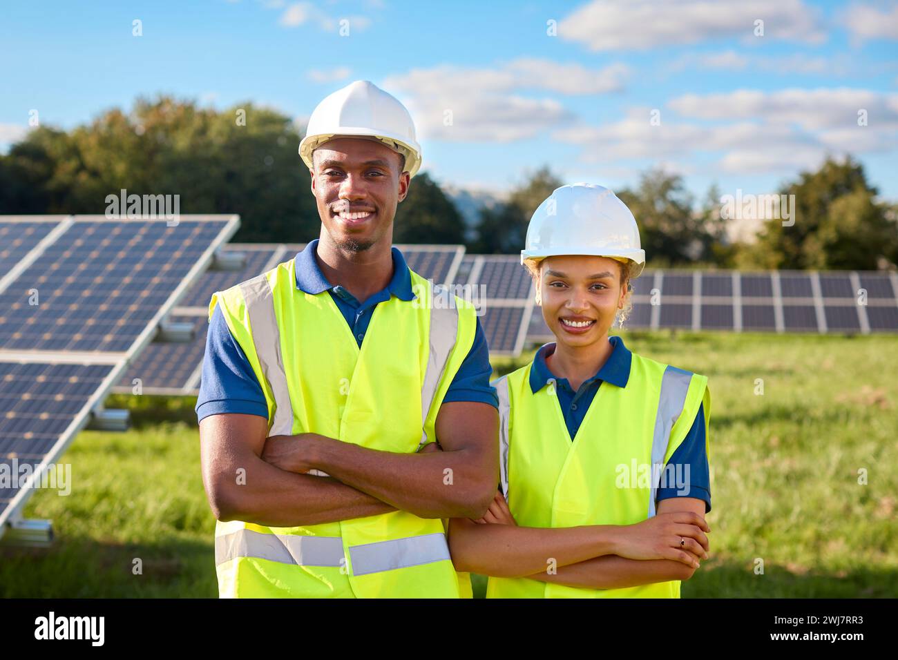 Portrait Of Smiling Male And Female Engineers Inspecting Solar Panels ...