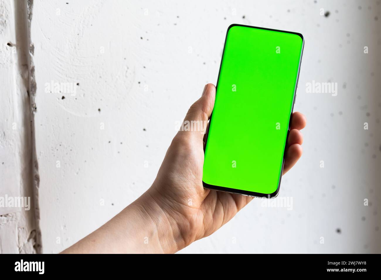 Mockup image of a person holding smart mobile phone with blank green ...