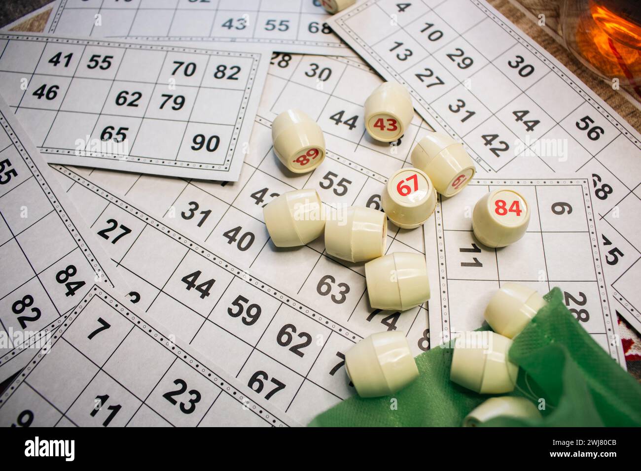 Playing lotto game. Cubes with figure on bingo card background. Nostalgia lifestyle. Table games. Retro games. Barrel with number and paper cards. Stock Photo