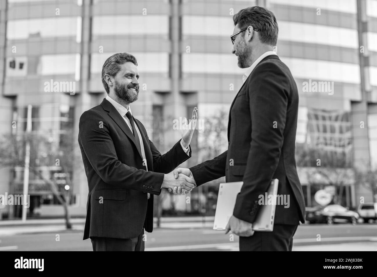 photo of positive two business men handshaking. two business men ...