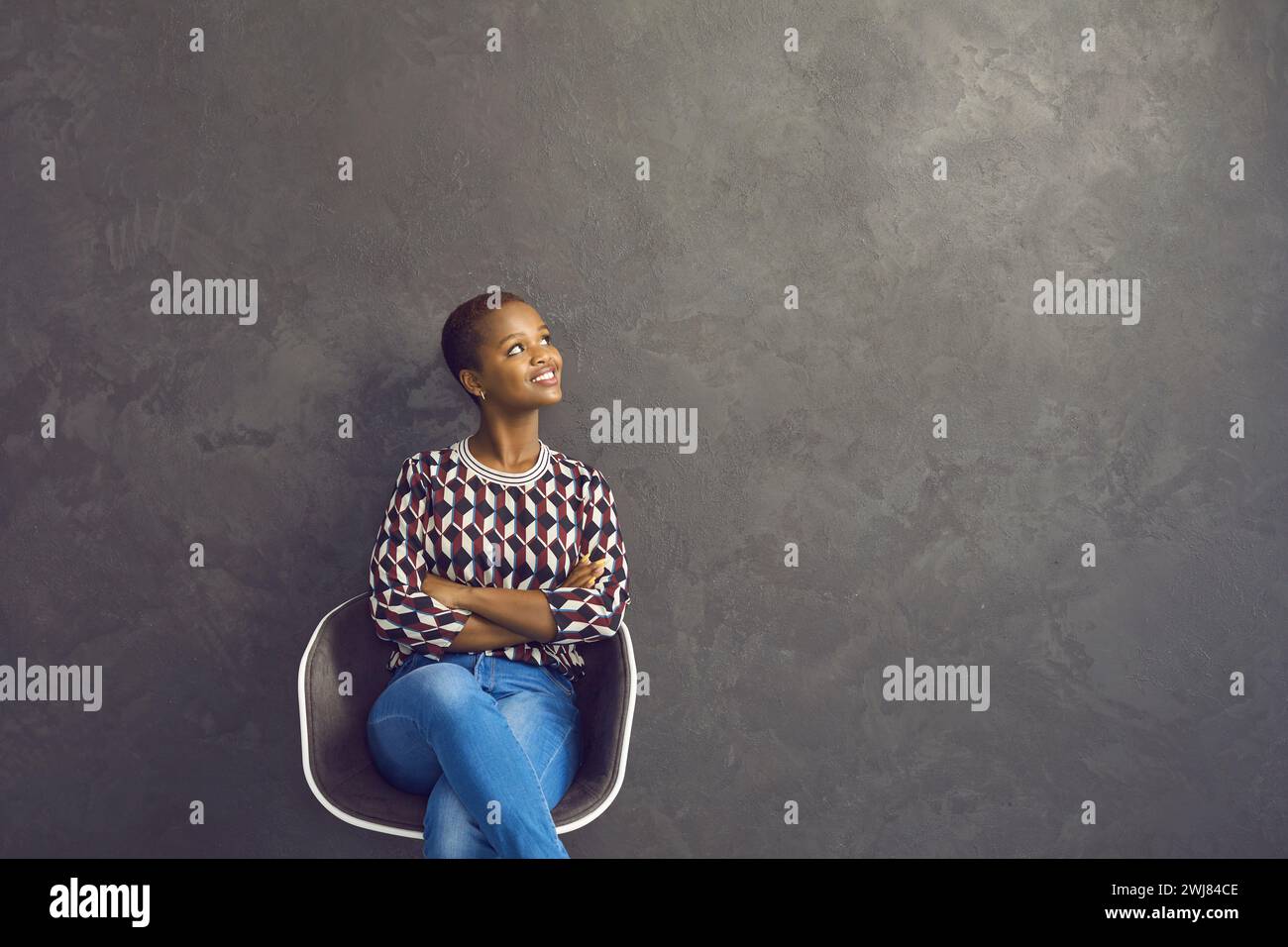 Portrait of smiling African American woman sitting on chair with ...