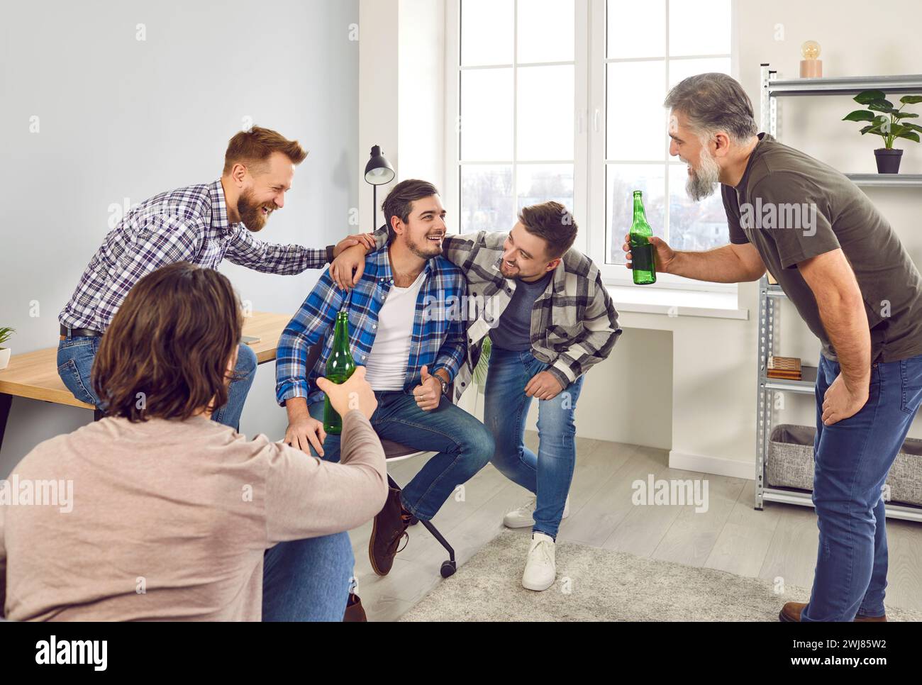 Group of happy male friends drinking beer at home Stock Photo