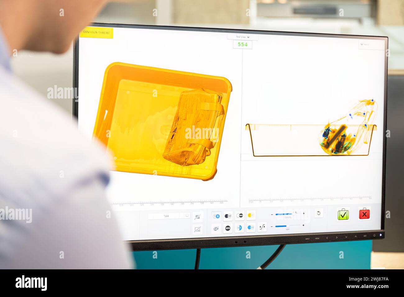 Airport security baggage screening. Security man looking at monitor