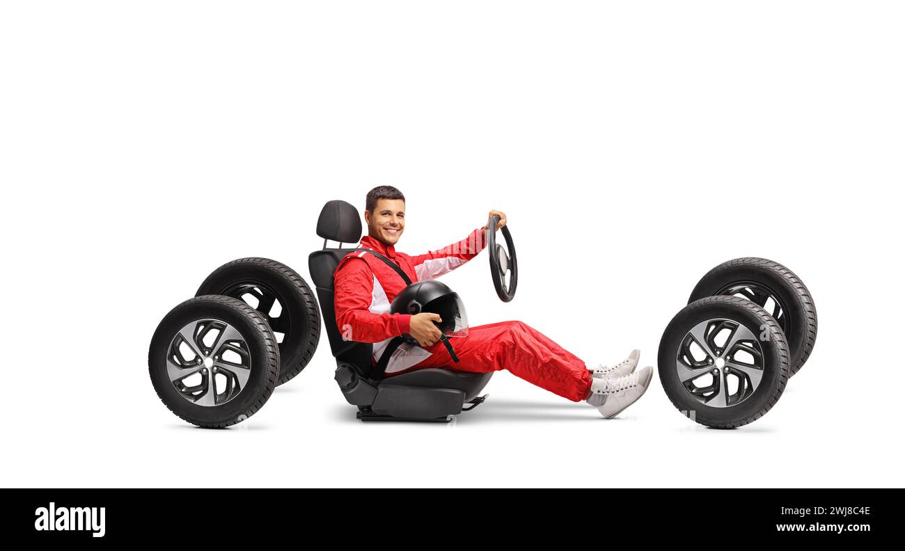 Racer in a car seat on four tires holding a helmet and a steering wheel isolated on white background Stock Photo