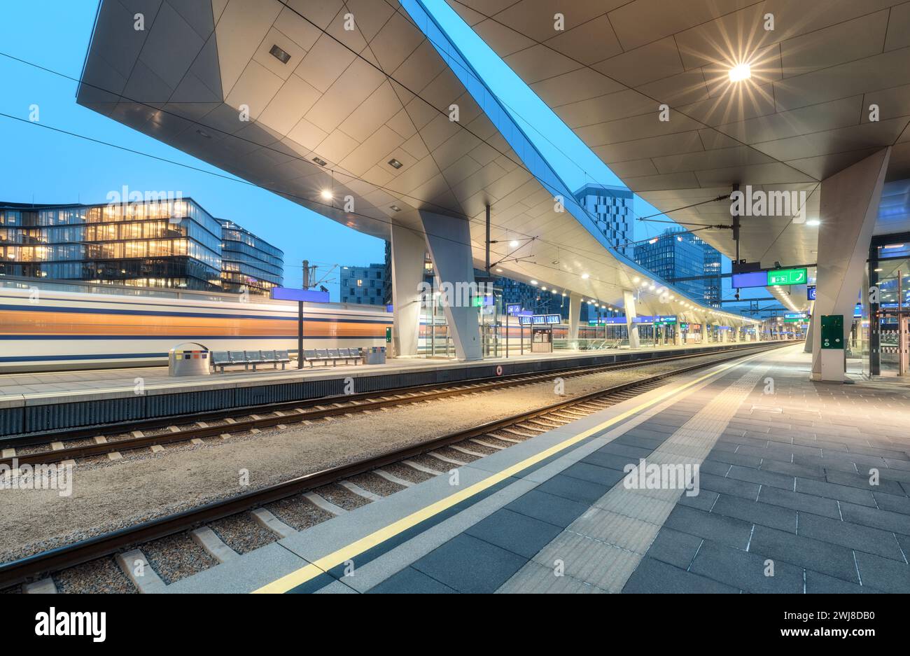 High speed train in motion on the railway station at night Stock Photo ...