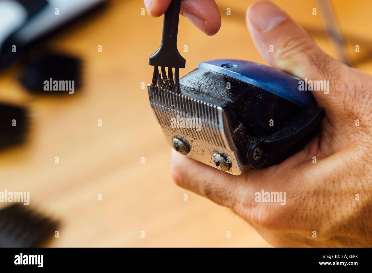 Barber cleaning his clipper. Close up view. Maintenance of work tool Stock Photo Alamy