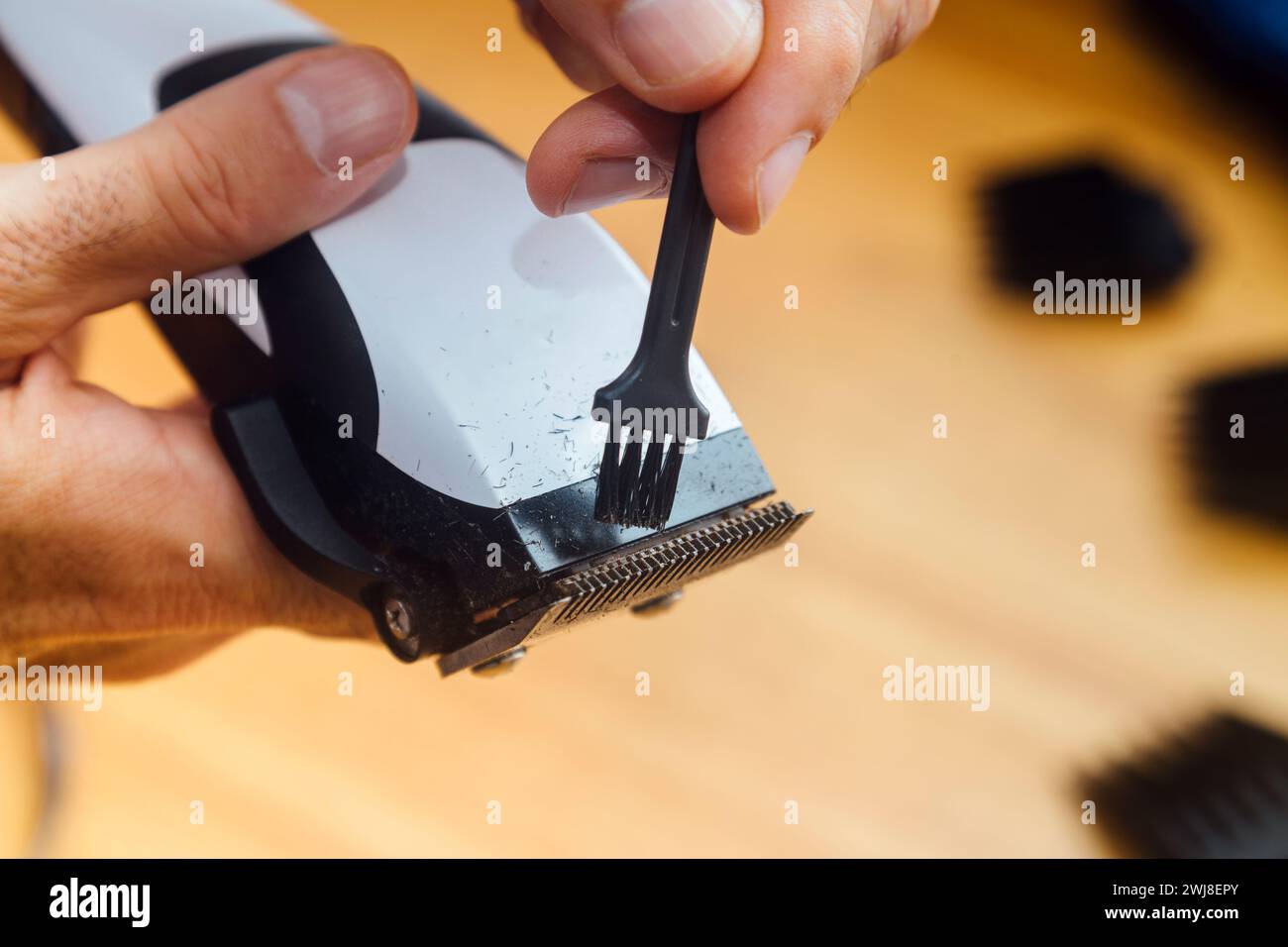 Barber cleaning his clipper. Close up view. Maintenance of work tool Stock Photo Alamy