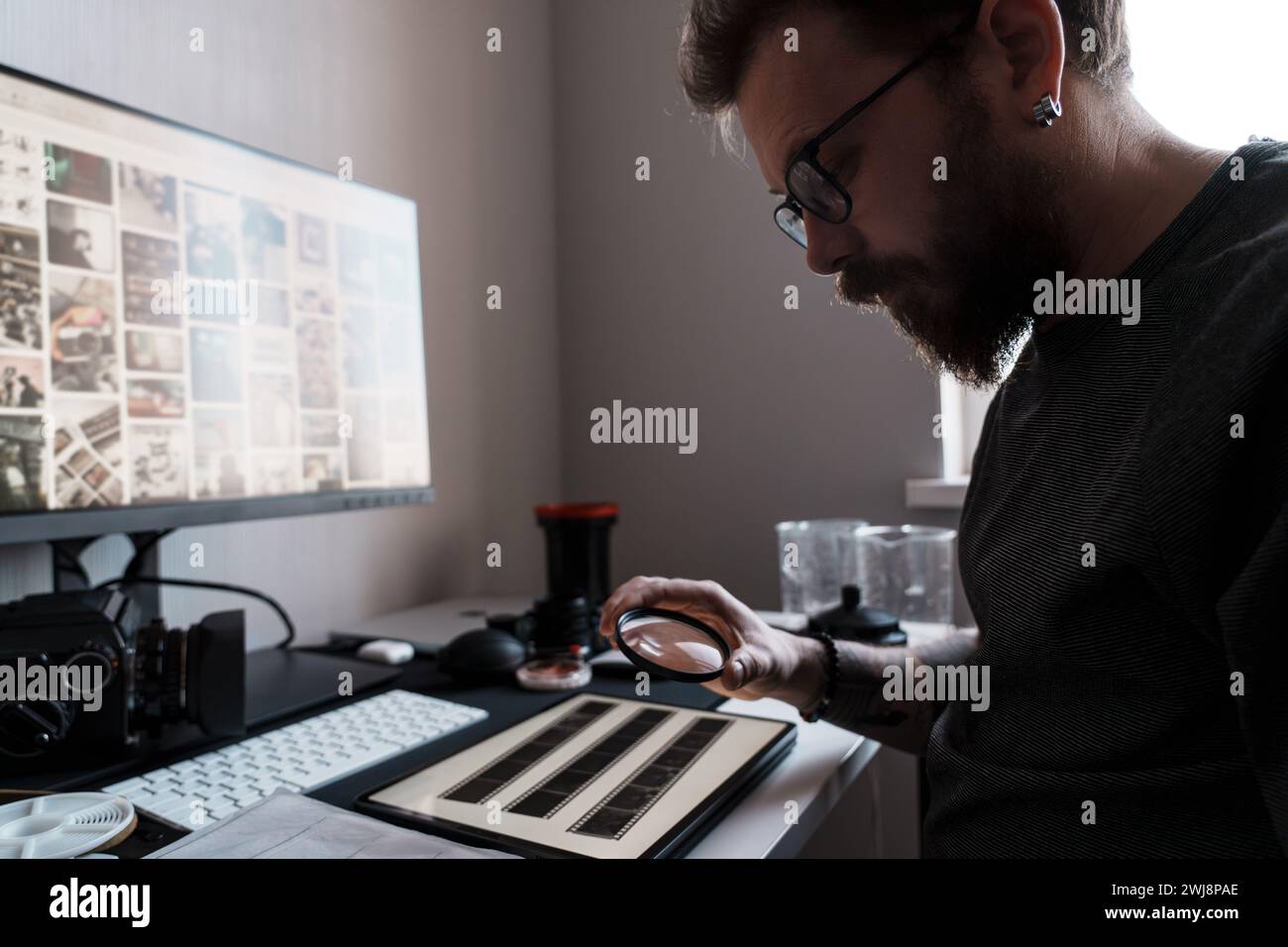 Photographer Inspects Negatives with Magnifying Glass Stock Photo Alamy