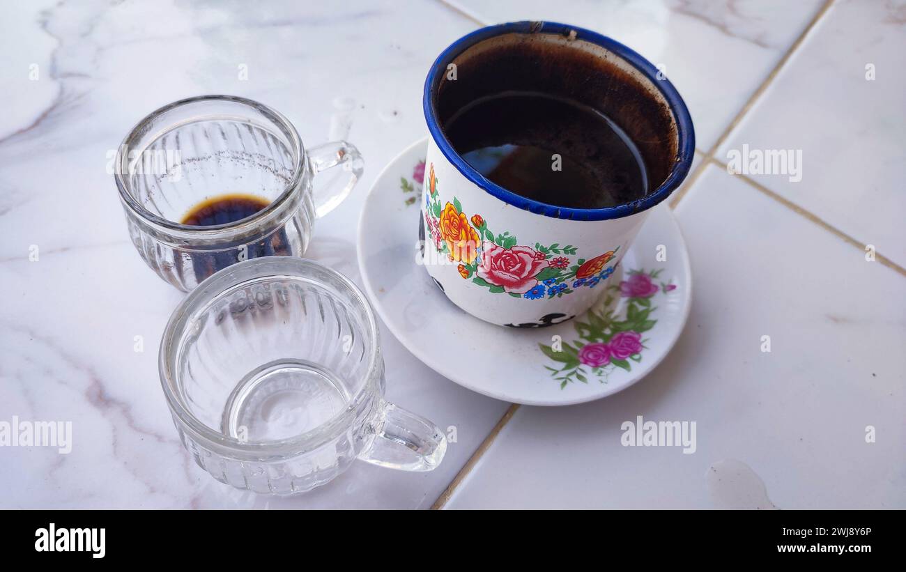 A cup of black coffee with two empty cups Stock Photo
