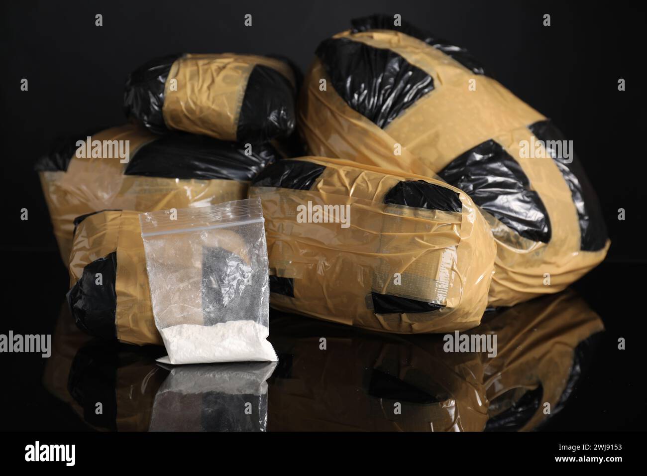 Smuggling and drug trafficking. Packages with narcotics on black mirror surface Stock Photo