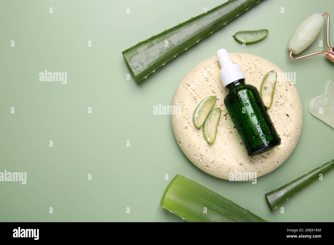 Flat lay composition with cosmetic products and cut aloe leaves on pale ...