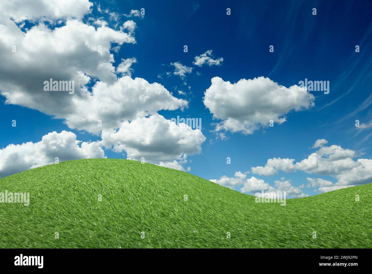 Lush green grass under blue sky with fluffy clouds Stock Photo - Alamy
