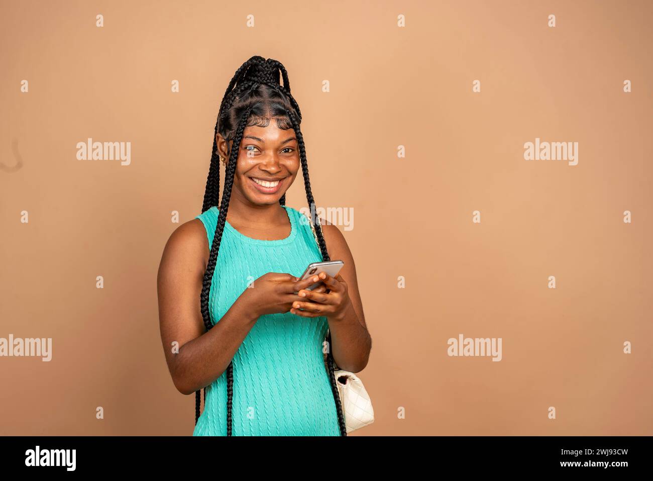 happy lady using her phone isolated over plain background Stock Photo