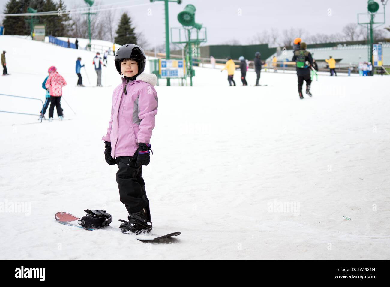Young Asian female child on snowboard in action Stock Photo - Alamy