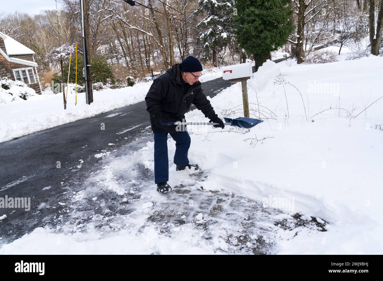 Chappaqua, NY Feb 13 2024 A man shovels out his driveway after a