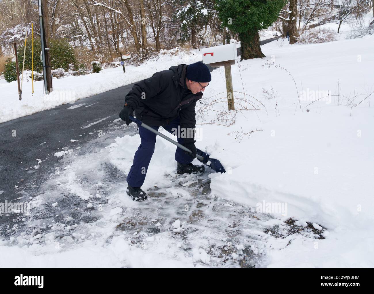 Chappaqua, NY Feb 13 2024 A man shovels out his driveway after a