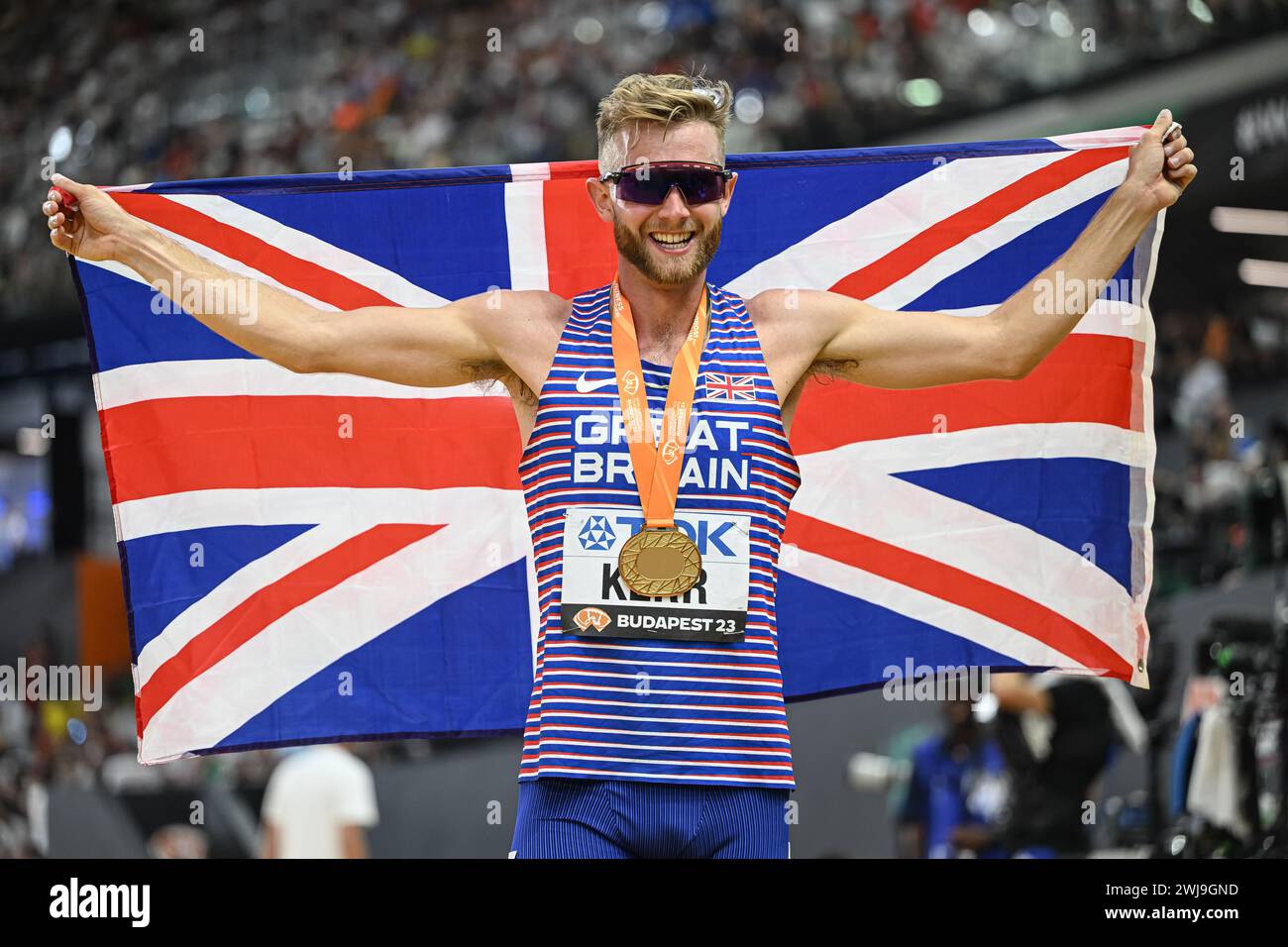 Josh KERR celebrating his medal with the flag in the Budapest 2023