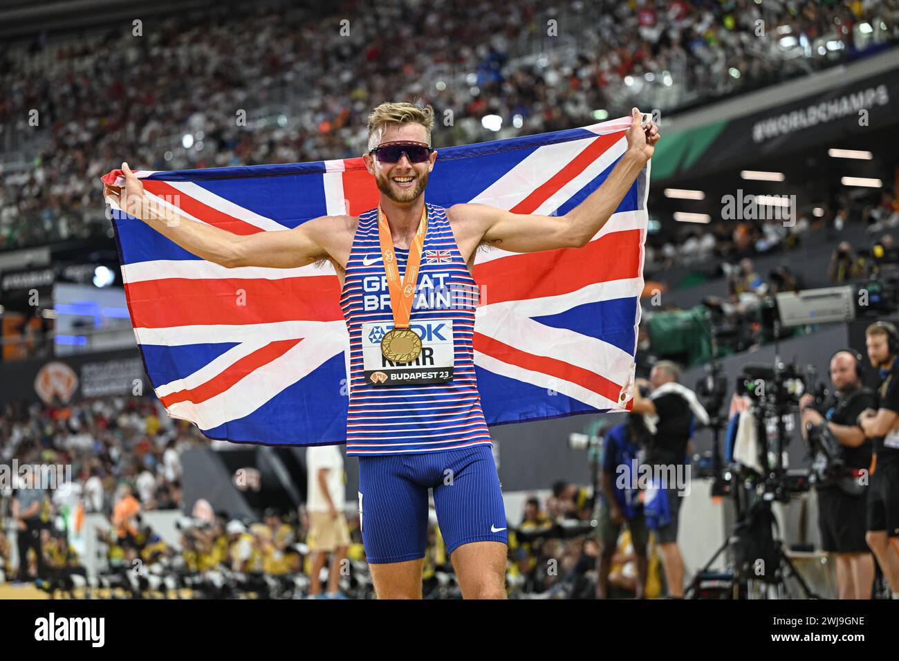 Josh KERR celebrating his medal with the flag in the Budapest 2023