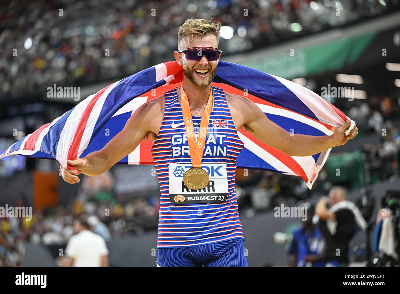 Josh KERR celebrating his medal with the flag in the Budapest 2023
