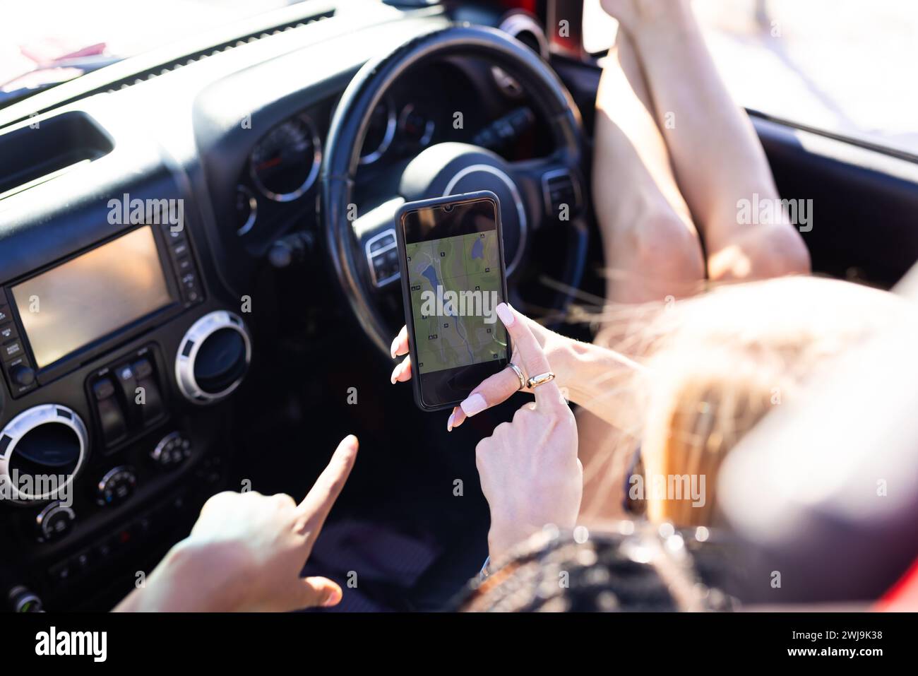 A person is using a smartphone for navigation in a car on a road trip