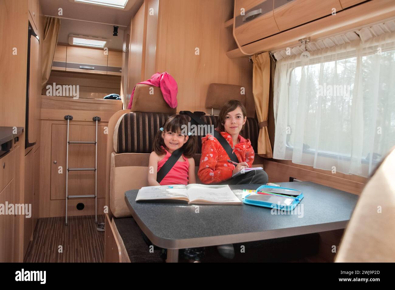 Family vacation, RV holiday trip, camping, happy smiling kids travel on camper, children in motorhome interior Stock Photo