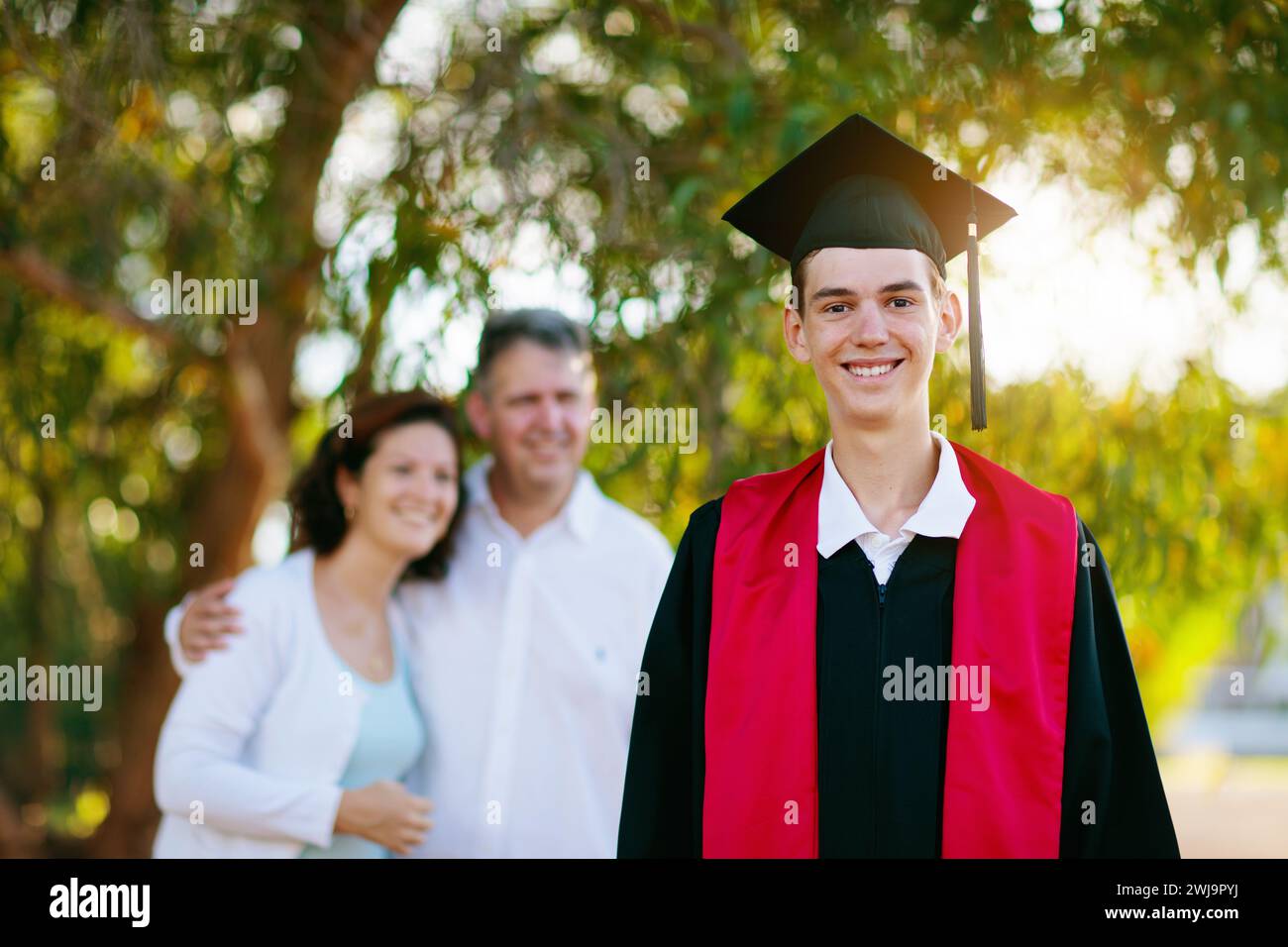 School Or College Graduation Ceremony. Young Man In Gown And Cap, With ...