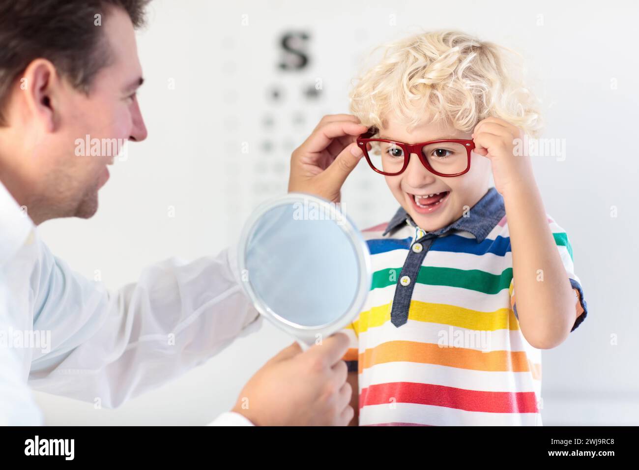 Child at eye sight test. Little kid selecting glasses at optician store. Eyesight measurement for school kids. Eye wear for children. Doctor Stock Photo