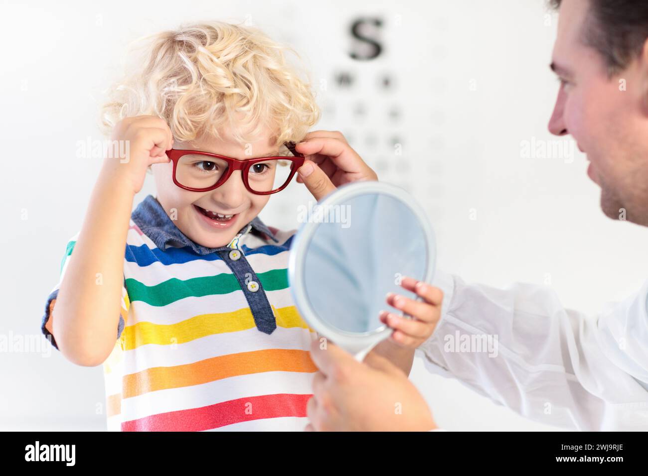 Child at eye sight test. Little kid selecting glasses at optician store. Eyesight measurement for school kids. Eye wear for children. Doctor Stock Photo