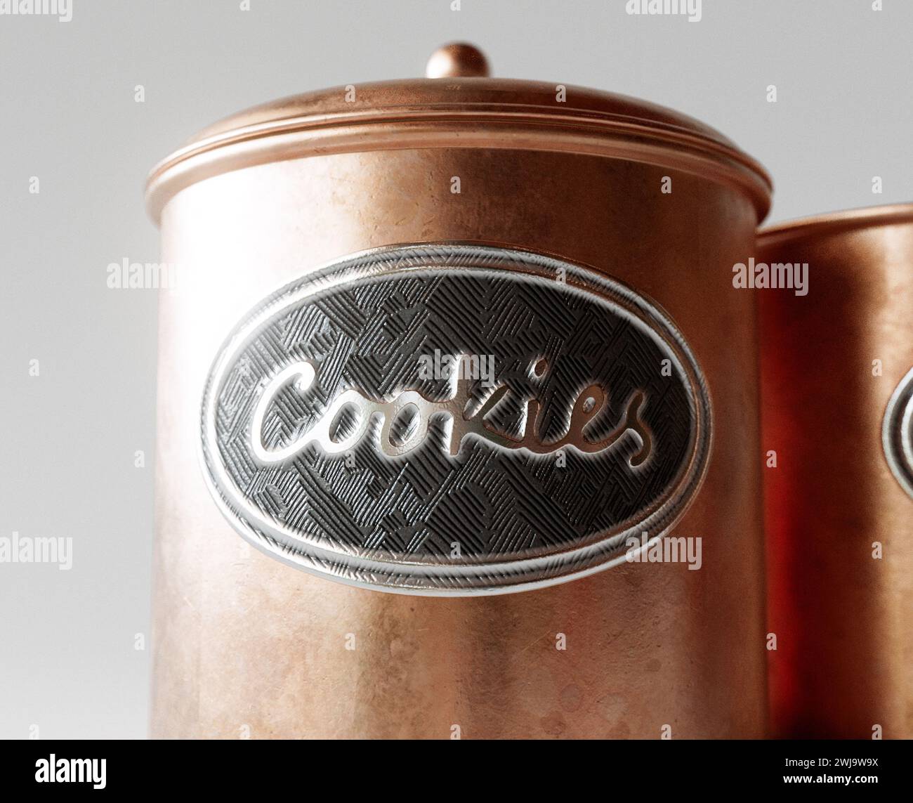 A concept showing two copper cookie jar tins with a metal embossed label on a white studio background - 3D Stock Photo