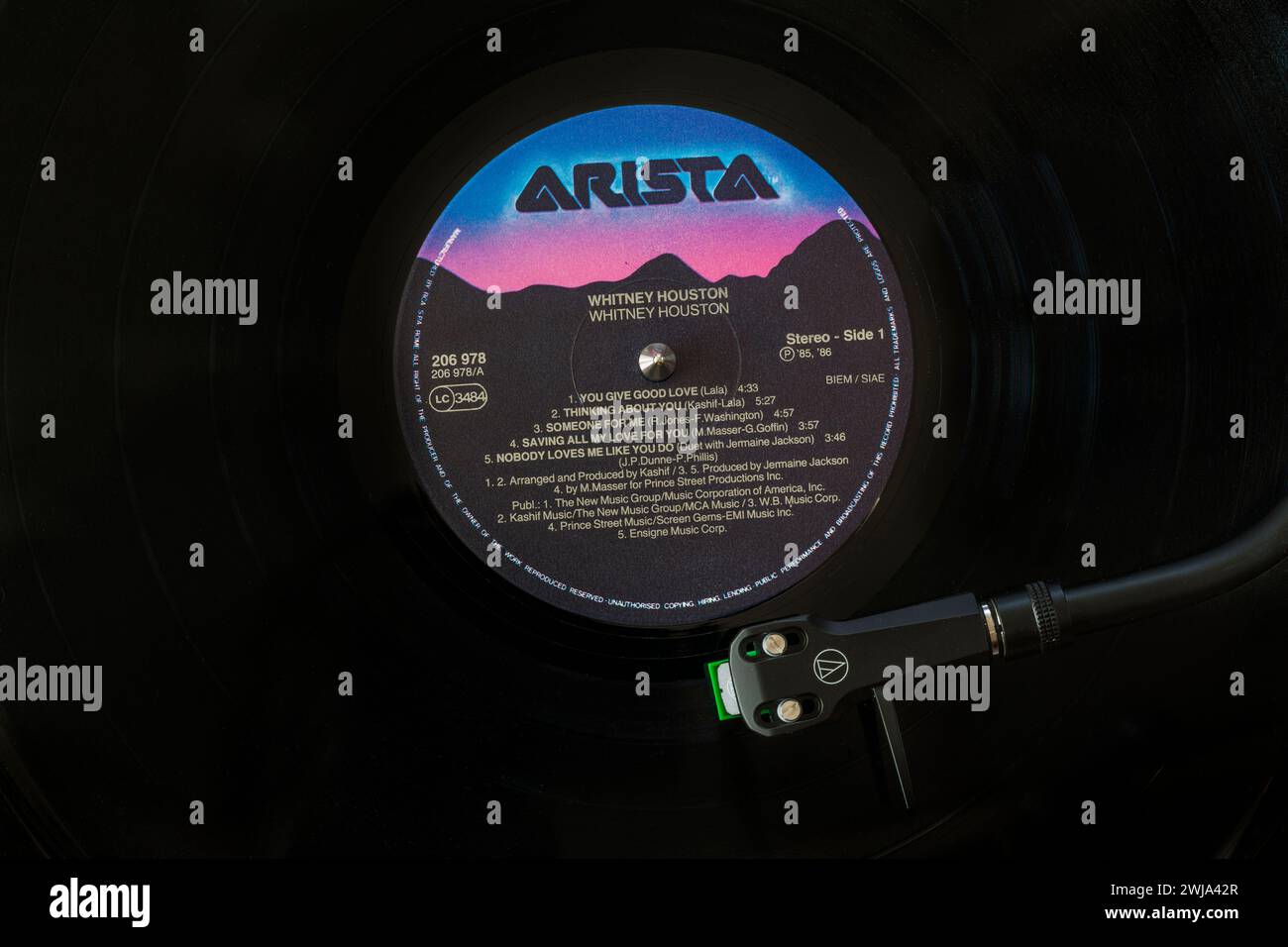 Whitney Houston vinyl record album LP with tonearm, cartridge, headshell and stylus on turntable record player - 1985 Stock Photo