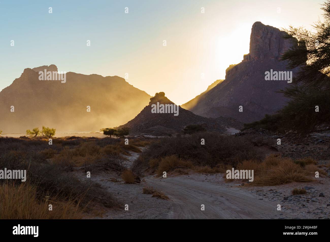 A majestic mountain bathed in the glow of a setting sun, with dramatic ...