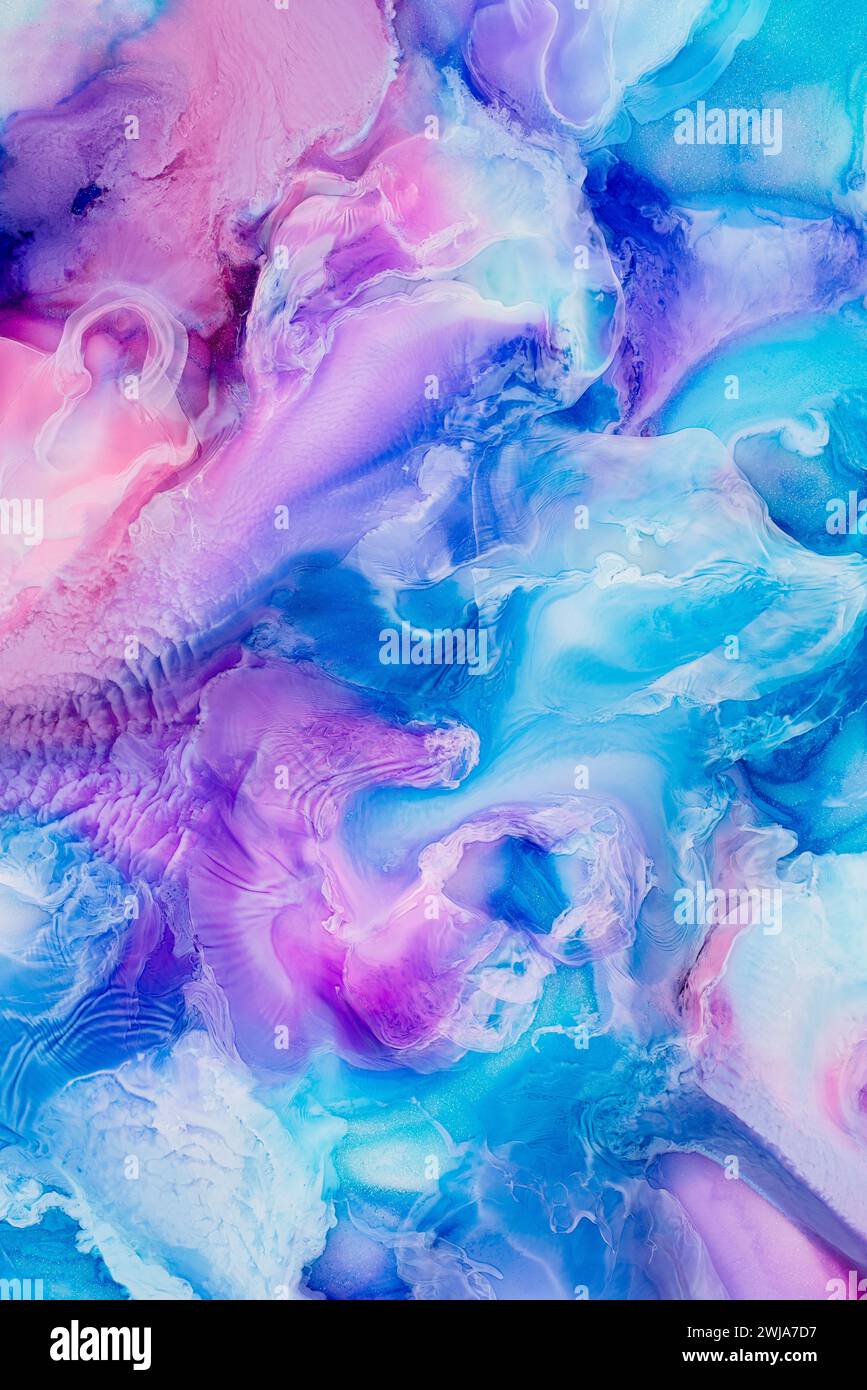 An abstract acrylic pour painting with vivid pink and blue hues, creating a dreamy liquid effect Stock Photo