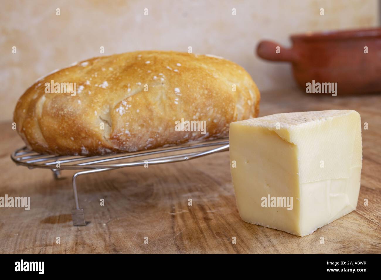 wedge of artisanal caciotta cheese near a loaf of homemade bread Stock Photo