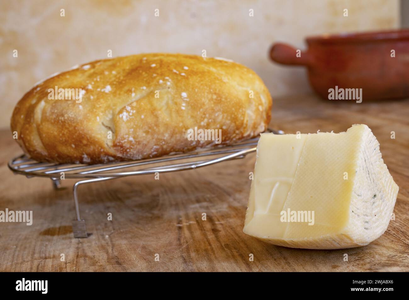 wedge of artisanal caciotta cheese near a loaf of homemade bread Stock Photo