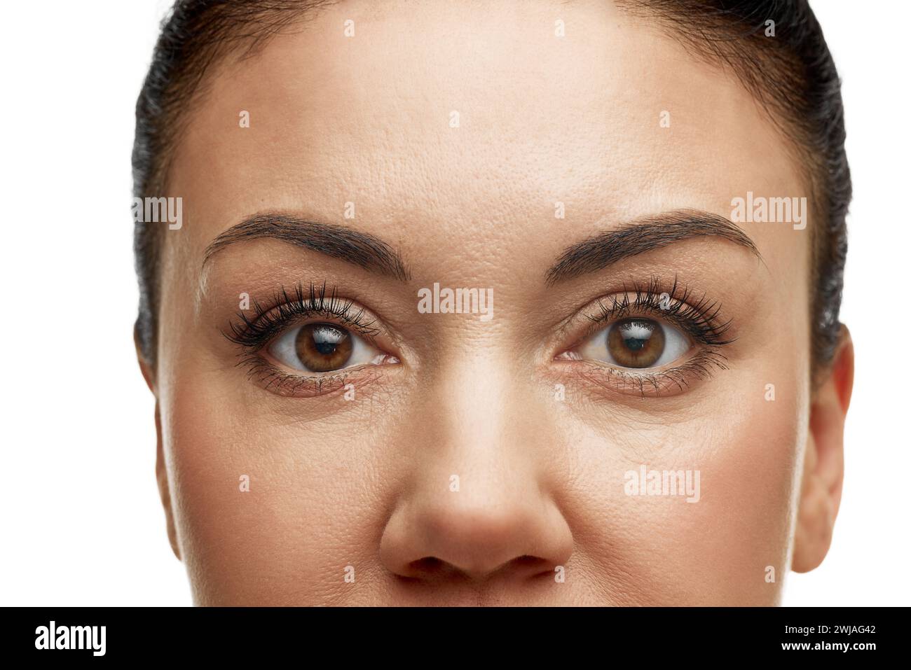 Cropped photo of woman, 40s years old, with well kept shiny skin against white studio background. Eyes and brows. Antiaging procedures. Stock Photo