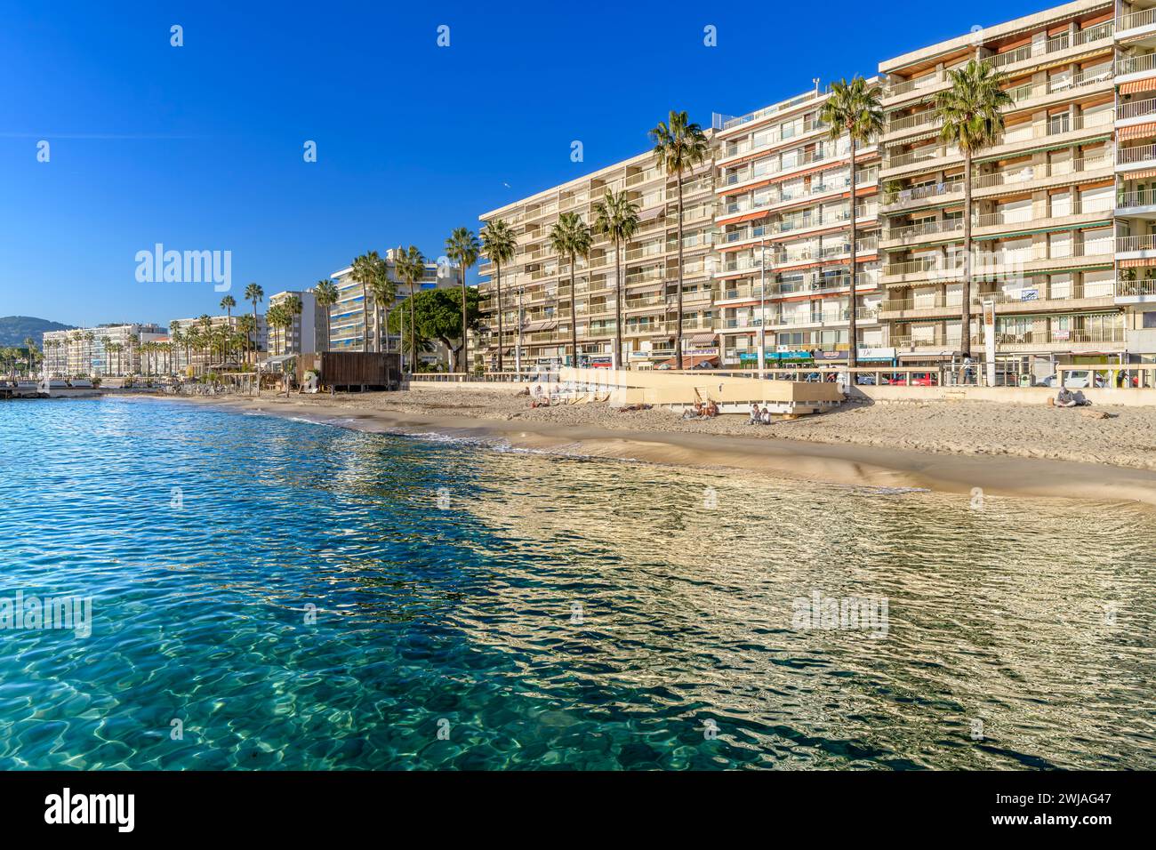 The seafront promenade and smart apartments of Juan Les Pins Beach in Antibes on the French Riviera, Côte d'Azur, France in November! Stock Photo