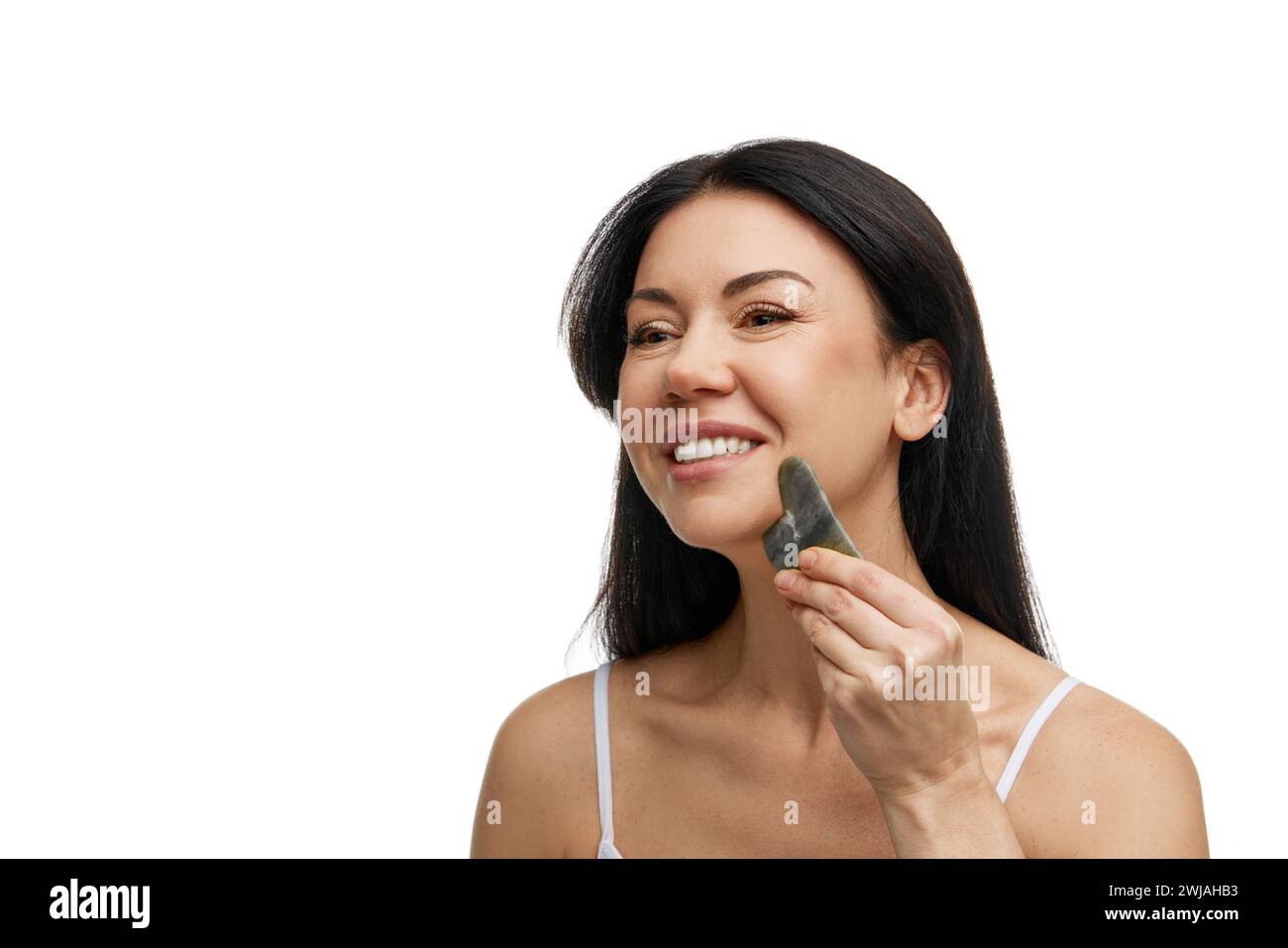 Portrait of delight woman doing massage of face, neck and decollete
