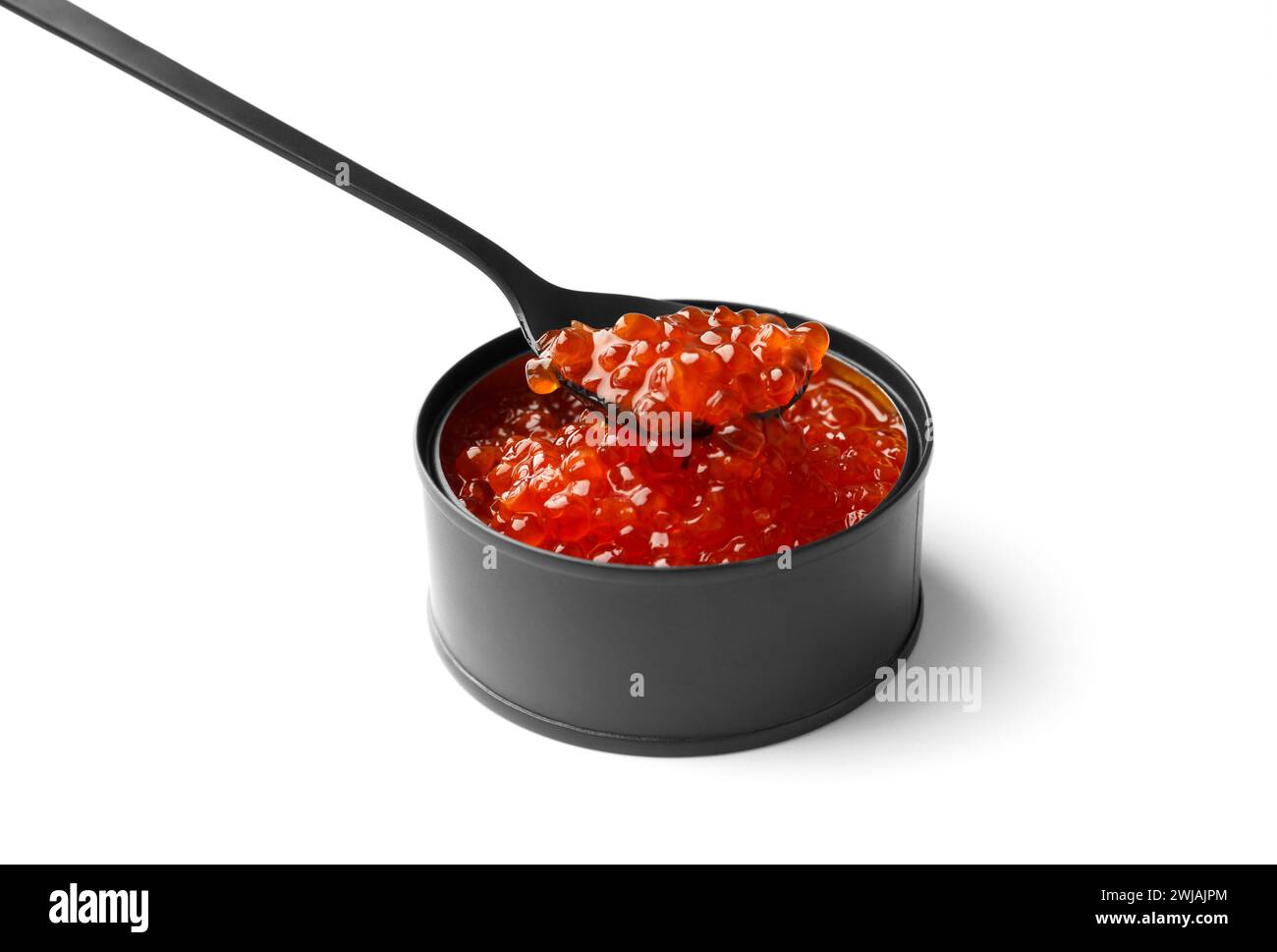 Red salmon caviar in a black tin can and in a black decorative spoon on a white background. Useful delicacy seafood, canned fish. Stock Photo