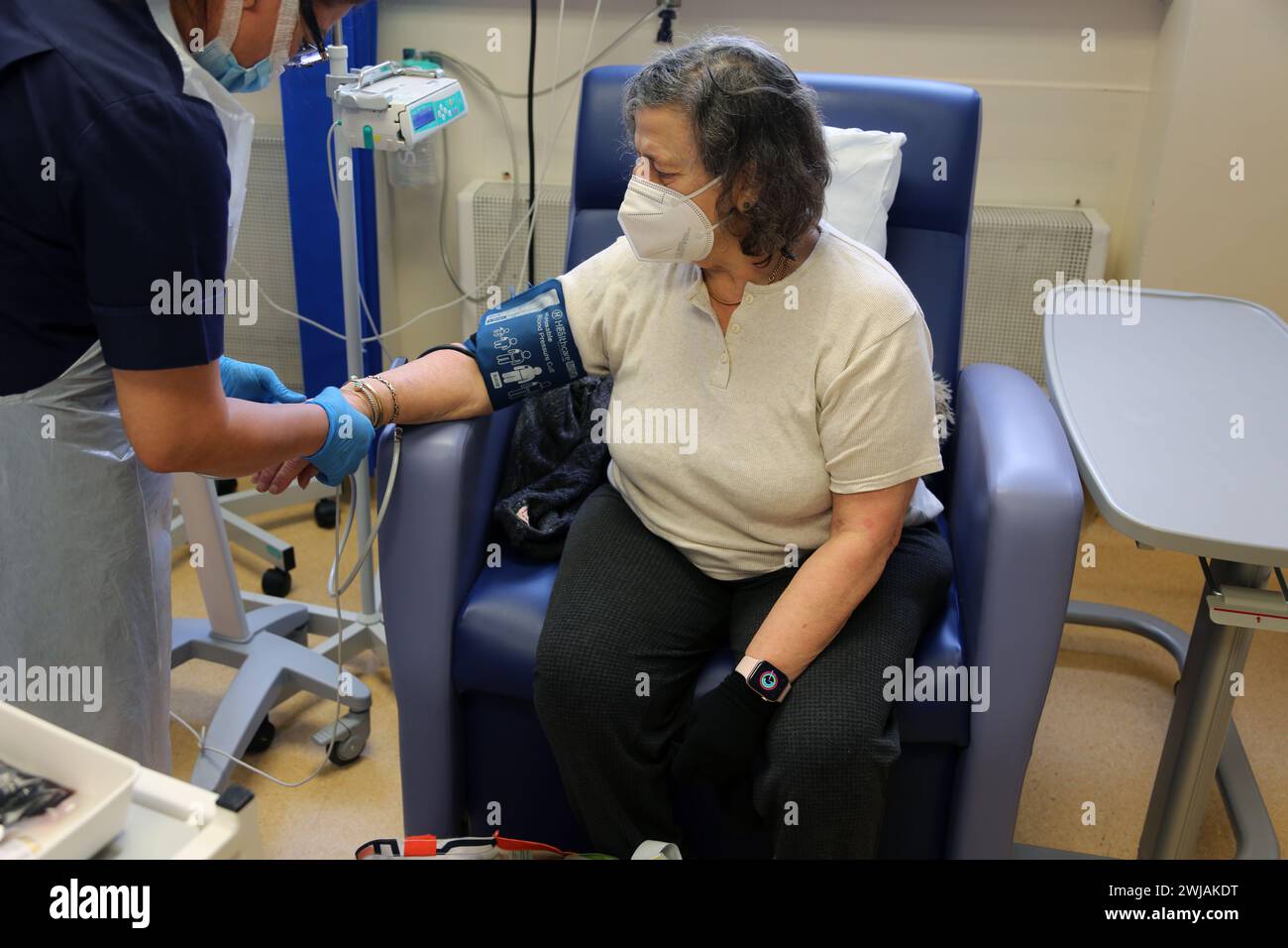 Nurse Using Blood Pressure Cuff on Patient before Administering an Iron Infusion At Hospital Surrey England Stock Photo