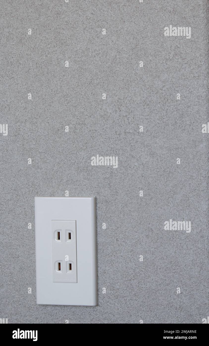 Japanese two pin electric plug socket on grey wall background Stock Photo