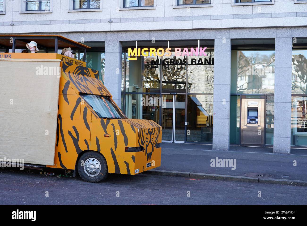 Anton Geisser 13.02. 2024 Schweiz Fasnachtswagen vor Migros Bank Logo Schriftzug *** Anton Geisser 13 02 2024 Switzerland carnival float in front of Migros Bank logo lettering Stock Photo