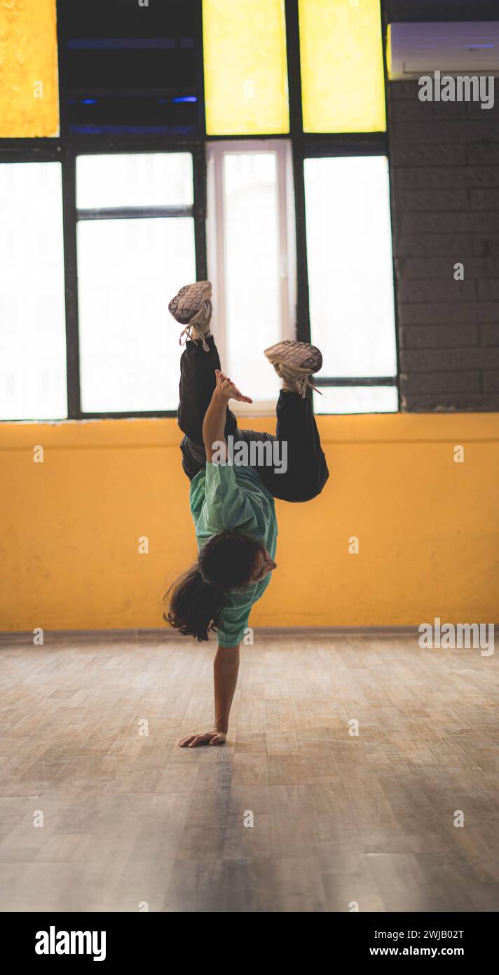 A woman performing break dance in a studio Stock Photo