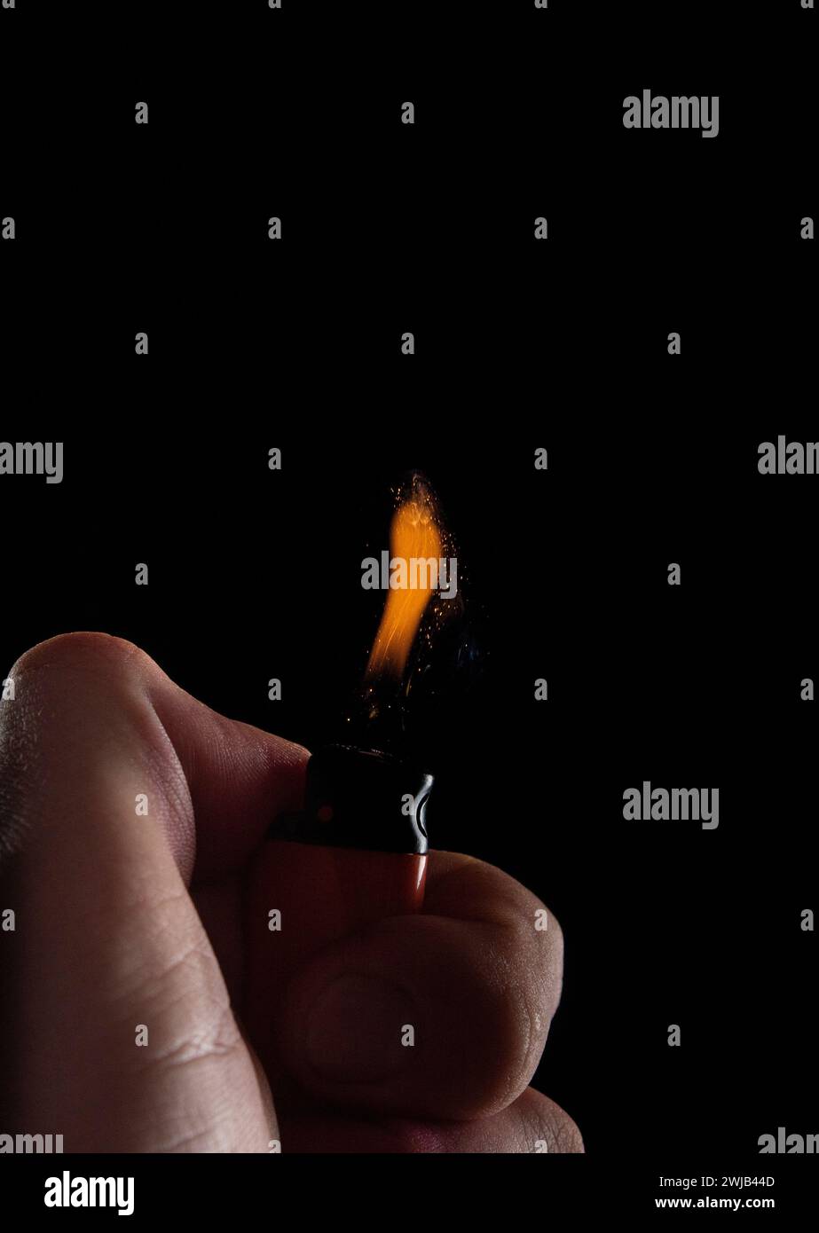 Hand with lighter igniting sparks Stock Photo