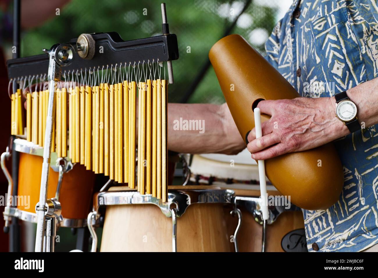 Percussionist Holding A Guiro In One Hand Whilst Playing A 36 Bar Mark
