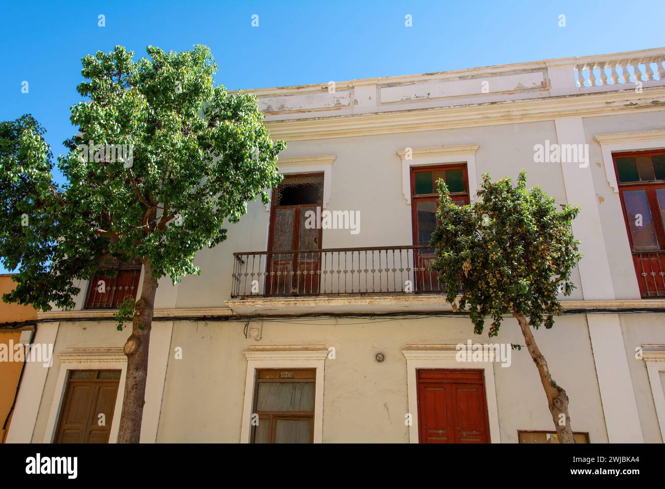 Old house with balcony and a tree in Spain on the Canary Island of Gran Canaria Stock Photo