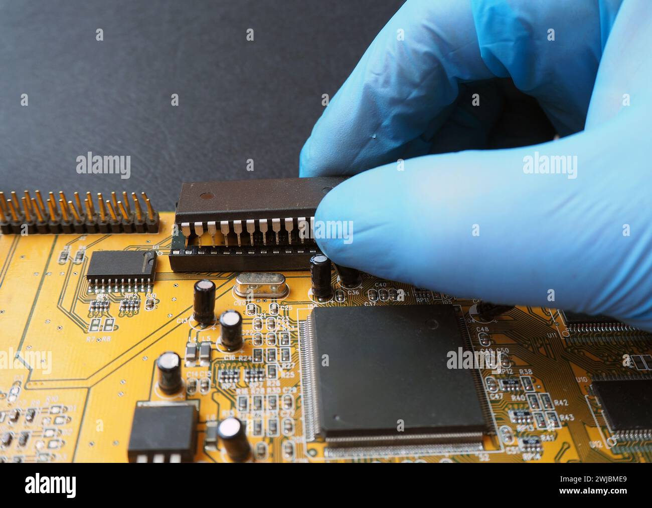 Removing an Integrated Circuit (IC) from the dip socket.   Semiconductor components on the electronic board. Stock Photo