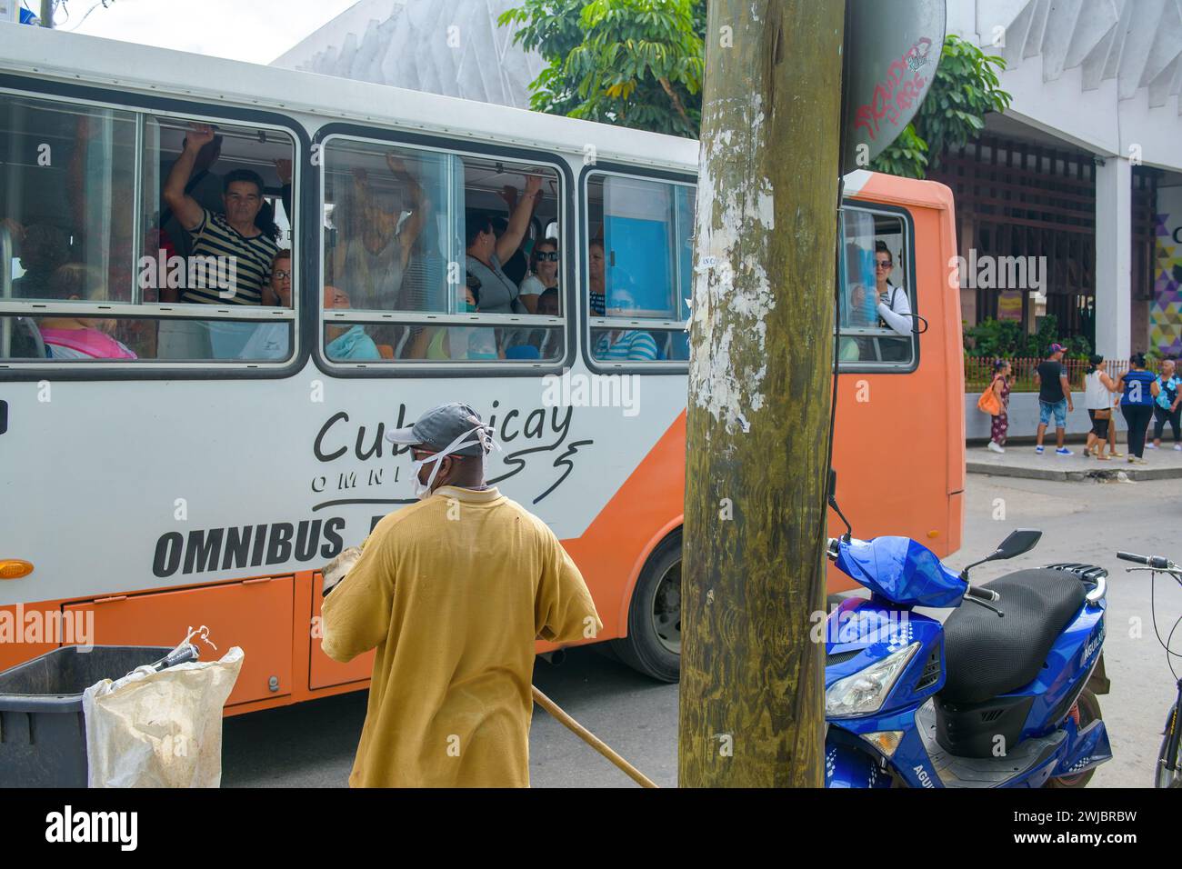 Crowded passenger bus and street sweeper, Santa Clara, Cuba Stock Photo