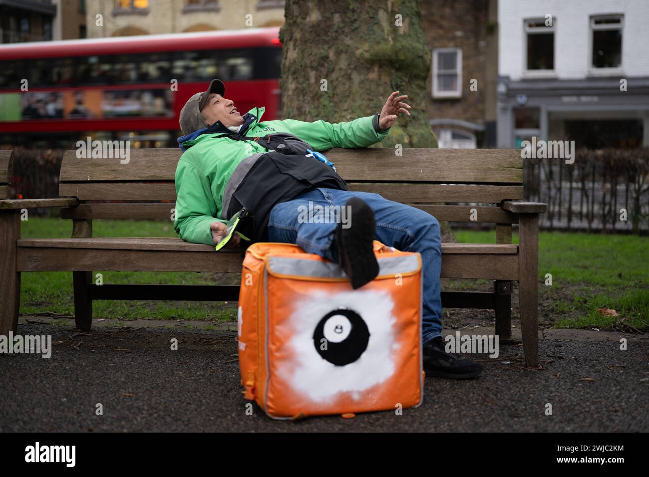 14th February 2024: An Uber Eats food courier takes a break between jobs in Islington Green, London. Deliveroo, and Uber Eats couriers are striking tonight between five and ten o’clock to secure better working conditions and pay. Stock Photo