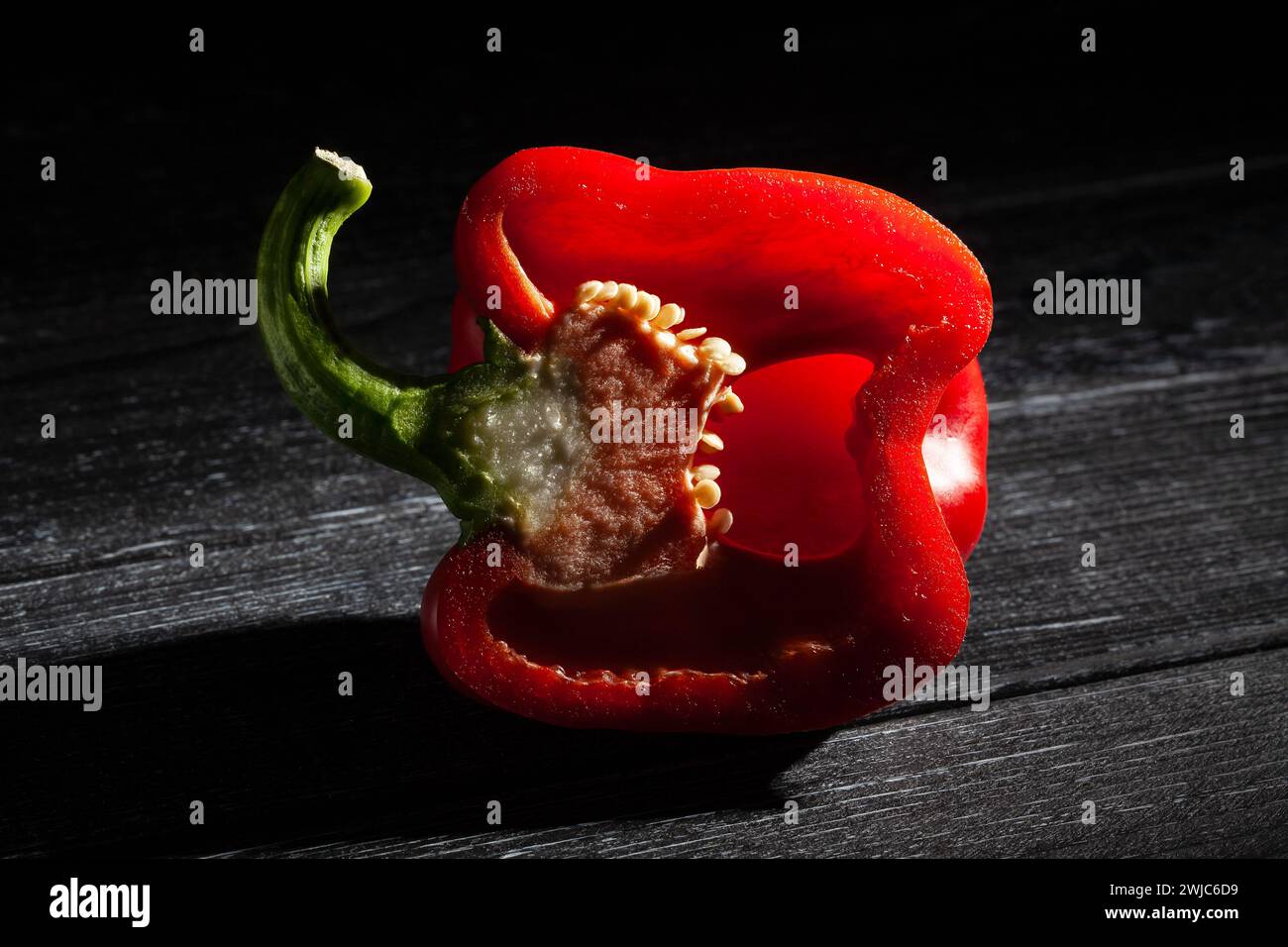 sliced red bell pepper on black wood background Stock Photo